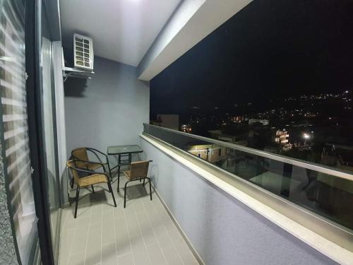 a balcony with two chairs and a table on a building at Apartmani Bosfor in Dobra Voda