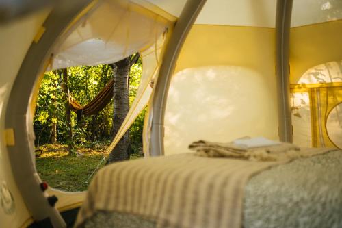 a bedroom with a bed in a tent with a window at Vrelo Glamping in Mandići