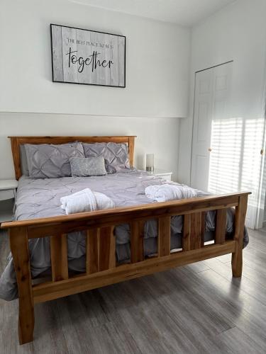 a bedroom with a large bed with a wooden frame at Westshore Garden Escape in Victoria