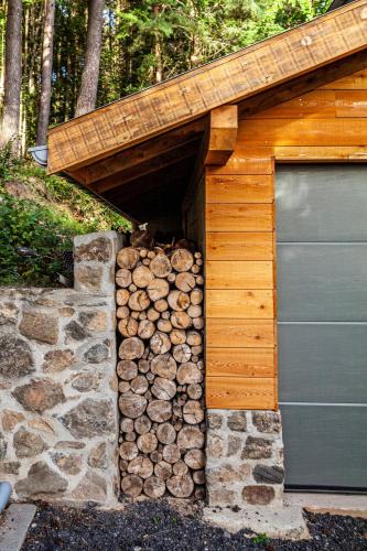 a pile of fire wood next to a garage at Le Chalet du Haut du Bout in Fraize