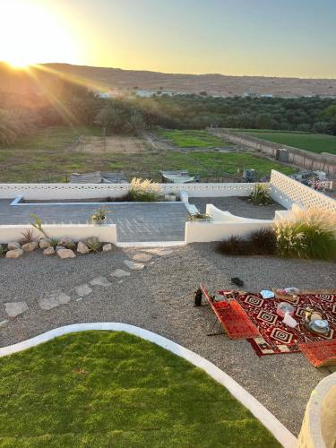 an aerial view of a garden with the sun setting at zahr albun villa in Al Raka