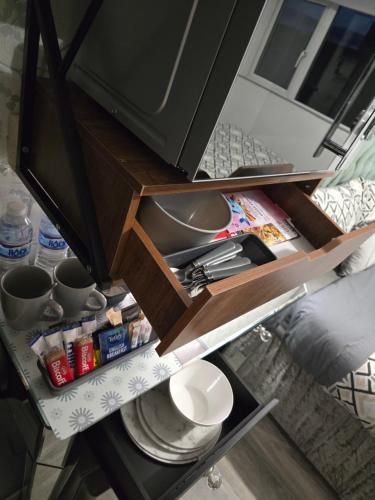 an open kitchen cabinet with food and utensils at Martello Bay Hotel in Clacton-on-Sea
