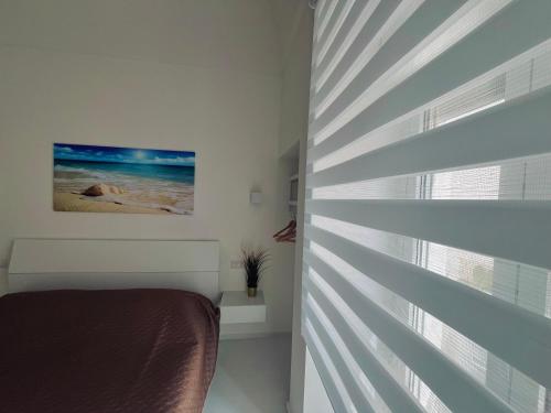 a bedroom with a bed and a window at Lmholiday SUNSET apartment in Torre Canne