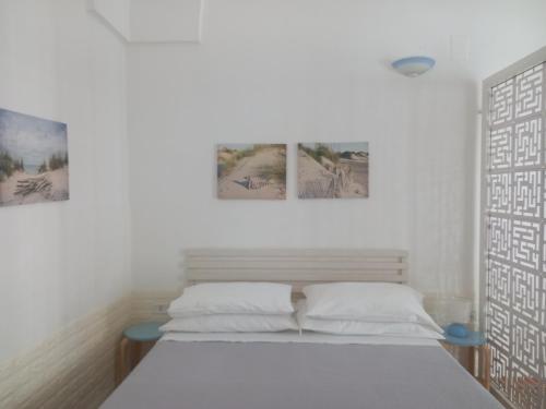 a bedroom with two beds and two pictures on the wall at M & G - Casa Vacanze in Santa Maria al Bagno