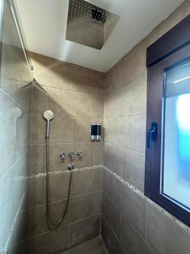 a bathroom with a shower with a glass door at La Casa del Pueblo con piscina y barbacoa in Rincón de Ballesteros