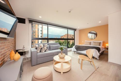 a bedroom with a king sized bed and a couch at Kyux Studios by MOME in Medellín