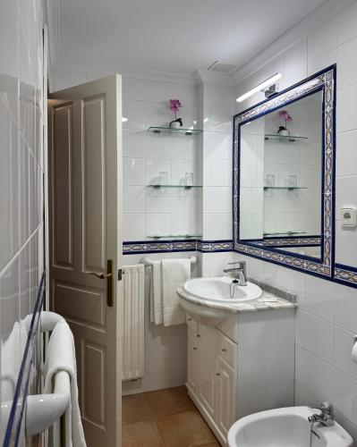 a white bathroom with a sink and a mirror at Hostería Miguel Angel in Santillana del Mar