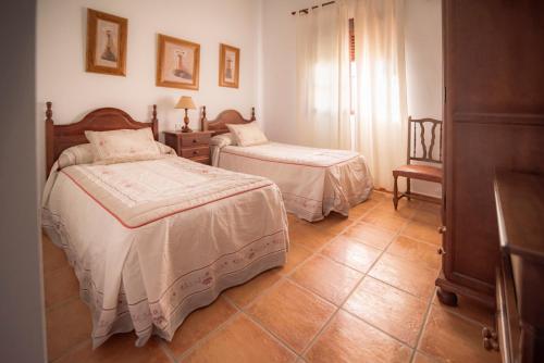 a bedroom with two beds and a dresser at Casa Rural Manuel Sevillano in Bornos