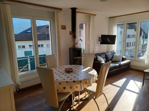 a living room with a table and chairs and a couch at Jobling's Holiday Apartment in Interlaken