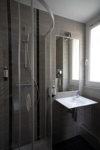 une salle de bain avec douche et lavabo dans l'établissement Hôtel Le Croiseur Ginette - Entièrement rénové, à Saint-Malo