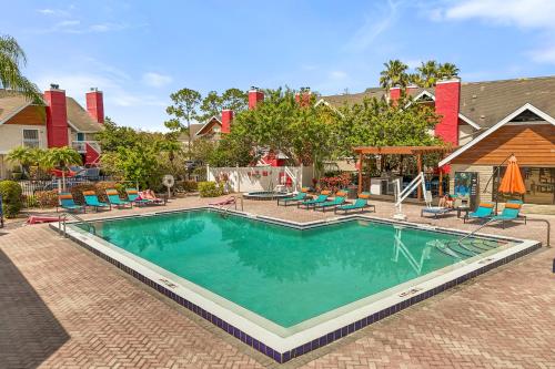 a large swimming pool with chairs and a house at Tranquil Haven 2BD 2BA Paradise 10min to Orlando's Best Theme Parks in Orlando
