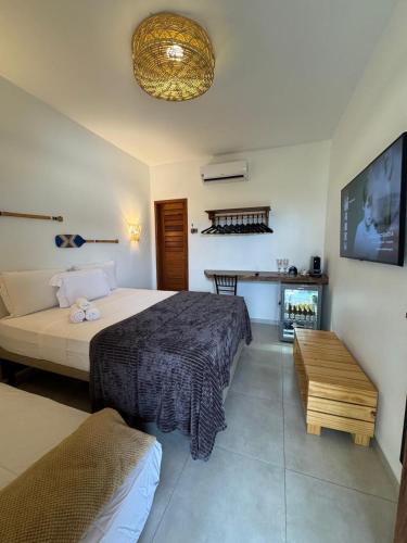 a bedroom with a bed and a couch and a tv at Pousada Amazing Jeri in Jericoacoara