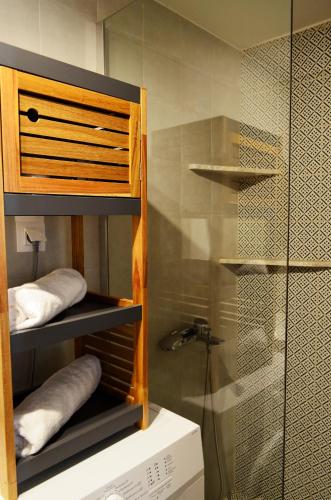 a bathroom with a shower and a shelf with towels at Guesthouse Evilia in Poros