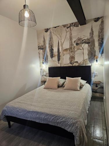 une chambre avec un lit avec un tableau sur le mur dans l'établissement L appartement du Clos Loret - Alençon, à Saint-Germain-du-Corbéis