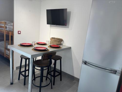 Il comprend une petite cuisine avec une table, des tabourets et un réfrigérateur. dans l'établissement Avant port, au Cap d'Agde
