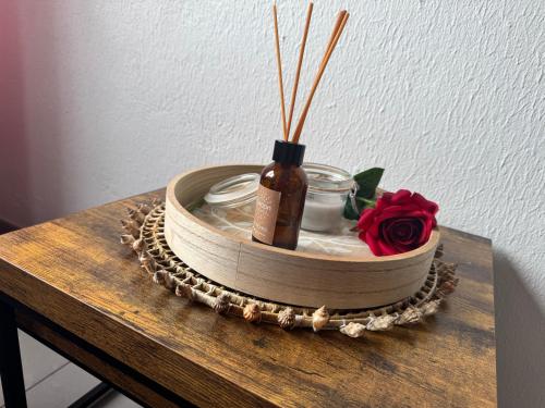 - un plateau en bois avec une bouteille et une fleur sur une table dans l'établissement Avant port, au Cap d'Agde