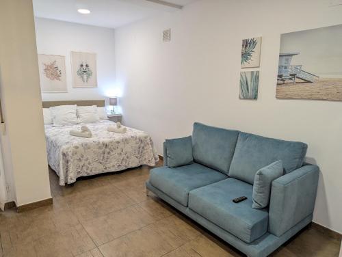 uma sala de estar com um sofá e uma cama em Estudios en la playa em Valência