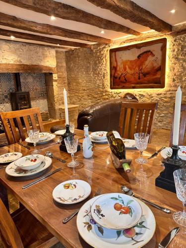 - une table en bois avec des assiettes et des bougies dans l'établissement Le Vieux Fournil, à Fanlac