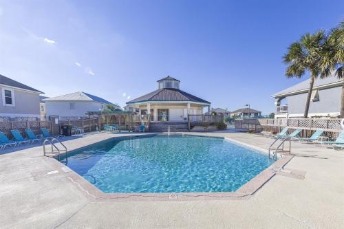 a swimming pool with chairs and a house at Gulf Shores Haven Pools Tent Tiki Bar Games Pool Table Early Checkin in Gulf Shores