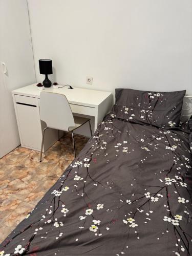 - une chambre avec un lit, un bureau et un couvre-lit orné de fleurs dans l'établissement Hogar Mediterráneo, à Valence