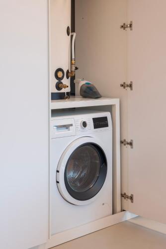 a washer and dryer in a white kitchen at Molly Apartments in Formigine