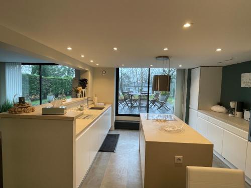 une grande cuisine avec une grande fenêtre et une table dans l'établissement La Glanerie, à Le Touquet-Paris-Plage