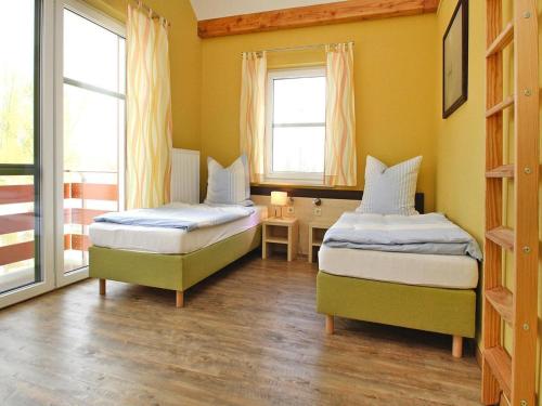 two beds in a room with two windows at Apartment by Lake Plau with Stunning Views in Plau am See