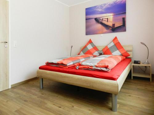 a bed with orange and white pillows on it in a room at Ferienwohnung Landblick, Rastede in Rastede