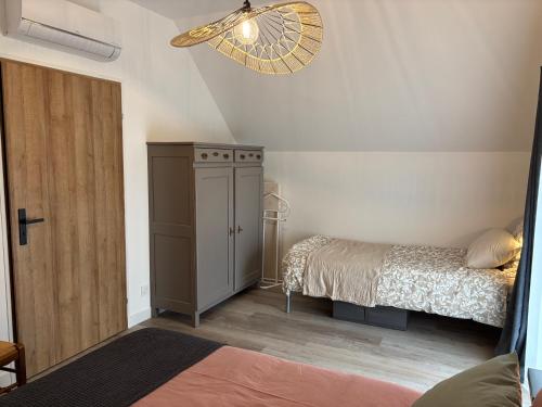 ein kleines Schlafzimmer mit einem Bett und einem Schrank in der Unterkunft Gîte les Huttières in Cravant-les-Coteaux