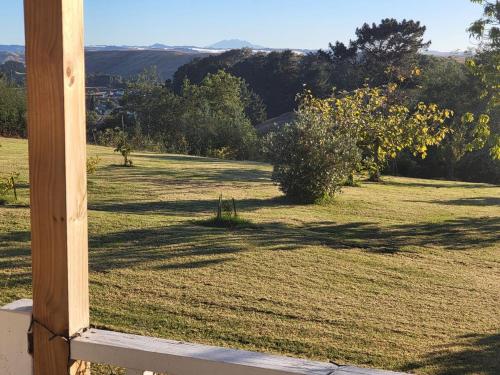 a view of a field of grass with a wooden pole at Gem on Bastia Hill in Whanganui