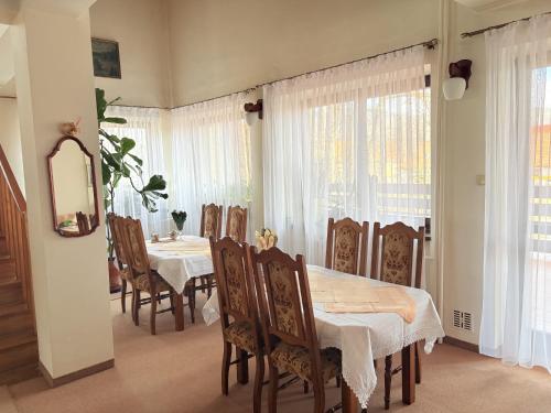 a dining room with a table and chairs and windows at Pensjonat Rezydencja Zuzanna Bed&Breakfast Sucha Beskidzka in Sucha Beskidzka
