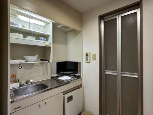 a kitchen with a sink and a counter top at ハレノヒハクシマ in Ōsukachō