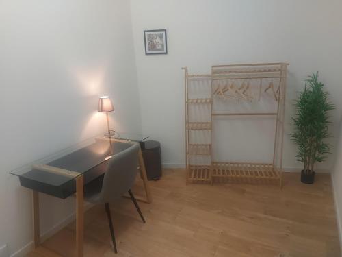 a room with a desk with a chair and a plant at Chambre confortable et indépendante - Proche aéroport, Lyon et la Plaine de l'Ain in Saint-Jean-de Niost