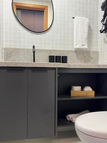 a bathroom with a sink and a mirror at Studio TEC Centro de convenções Smart Home in Salvador