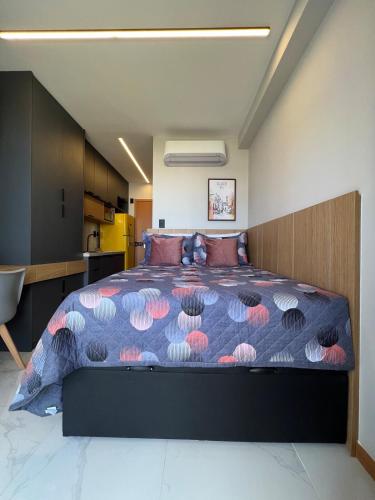 a bedroom with a large bed with a colorful comforter at Studio TEC Centro de convenções Smart Home in Salvador