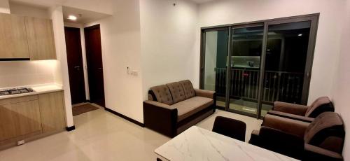 a living room with a couch and a chair and a kitchen at The Anchorage Grand Colombo AT TRI-ZEN COLOMBO 02 in Colombo