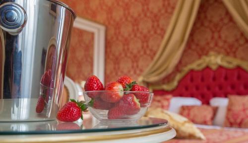 un tazón de fresas sentado en una mesa de cristal en Luxury Suites in Venice-Friendly Venice Suites en Venecia