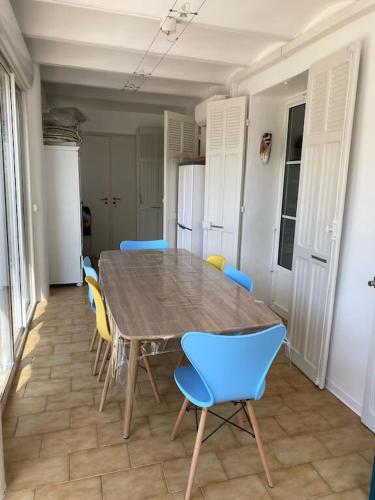 - une table à manger avec des chaises bleues dans l'établissement Appart 2 Ch et 1 traversante avec terrasse et jardin proche plage, à Bandol
