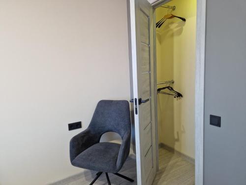 a blue chair in a room with a closet at VIN service Atbrivosanas alley 119 in Rēzekne
