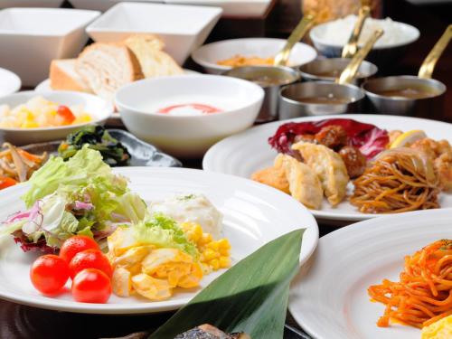 a table topped with white plates of food at J Hotel Rinku in Tokoname