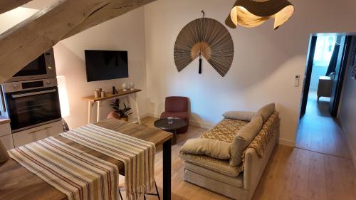 a living room with a couch and a table at Dijon Hypercentre - Loge Pompon in Dijon