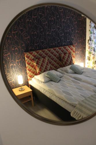 a mirror reflecting a bed in a bedroom at Huoneisto Villa Kymppi in Kuusamo