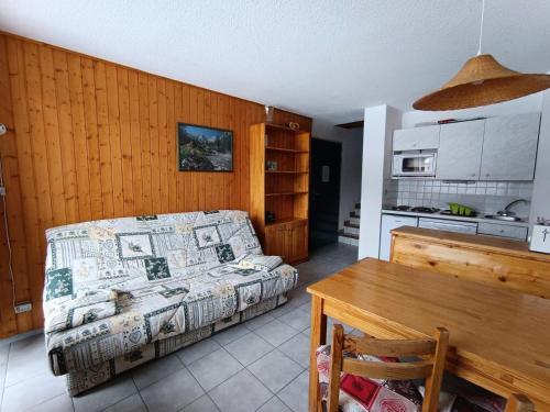 une chambre avec un lit et une table et une cuisine dans l'établissement Résidence Ferme D'augustin - Batiment I - Studio pour 2/4 personnes - Skis aux pieds MAE-9084, à Montgenèvre