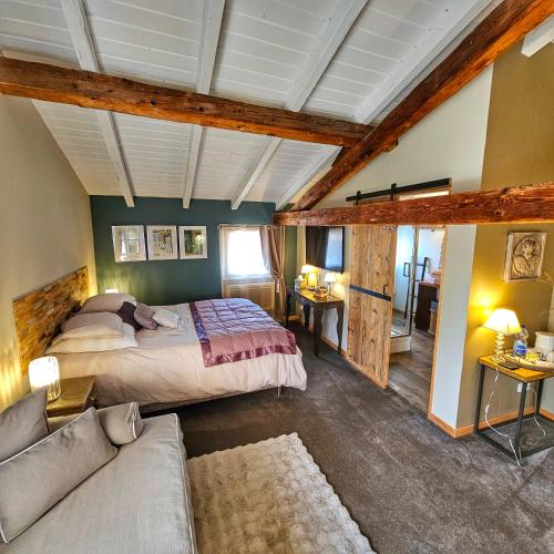 une chambre avec un lit et un canapé dans l'établissement La Grange du couvent B&B, à Ribeauvillé