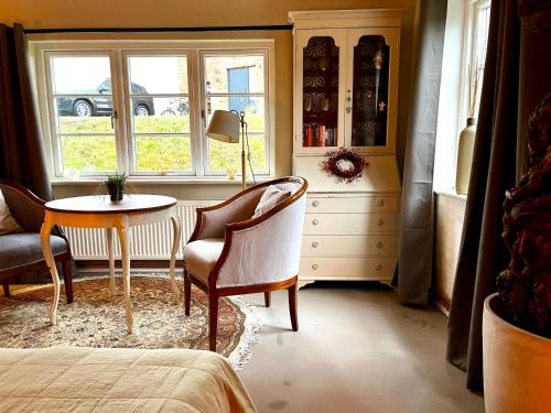 a bedroom with a table and a chair and a window at Elbkoje in Drage