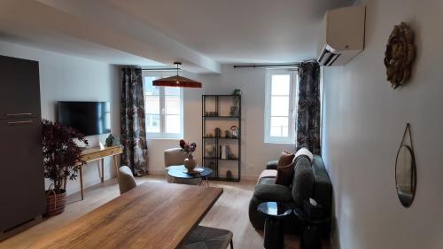 a living room with a couch and a table at Dijon Hypercentre - Loge de la chouette in Dijon