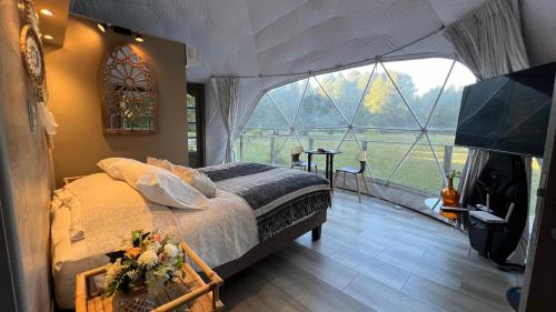 En eller flere senge i et værelse på Domo Refugio