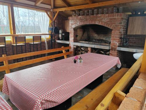 a kitchen with a table and a brick fireplace at Jerry's Forest in Banja Luka