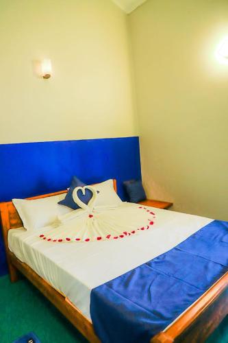 a bedroom with a large bed with a blue headboard at Reheboth Hotel in Trincomalee