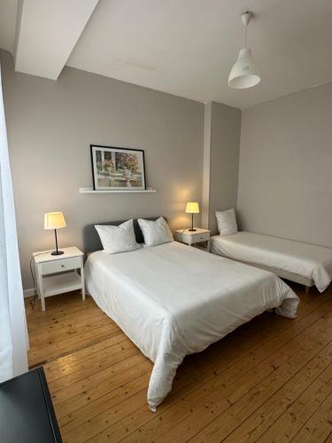 2 camas en una habitación con 2 mesas y 2 lámparas en Hyper Centre Krutenau Étoile Bourse Appart, en Estrasburgo